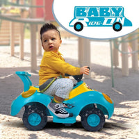 A bright blue and yellow PamPam Kids Electric Ride-on Car with a black steering wheel and red headlights. Musical notes are depicted floating above the car. Included alongside the car are a grey rectangular battery, a black power adapter, and a separate yellow and blue control panel.