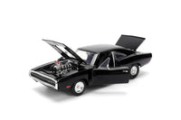 A black die-cast model car, a Dodge Charger from the Fast & Furious franchise, is viewed from the rear passenger side, showing its detailed body, chrome bumper, and distinctive rear lights.